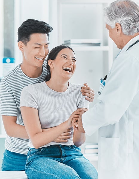 happy couple with doctor announcing pregnancy